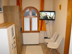 巴拉通尤洛克Ezüsthíd Apartman的客厅配有电视、椅子和窗户