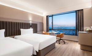 上海上海虹桥机场城际酒店的酒店客房设有两张床和大窗户。