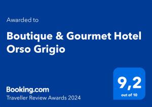 圣坎迪朵Boutique & Gourmet Hotel Orso Grigio的蓝色的标志读了精品美食酒店或聚居区
