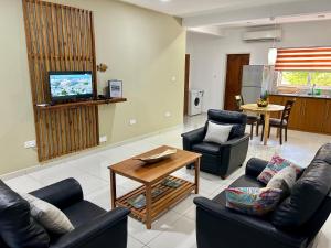 马埃岛The Seaboards Apartments Seychelles的客厅配有两张沙发和一台电视