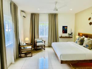 马埃岛The Seaboards Apartments Seychelles的卧室配有床、椅子和窗户。