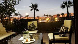 马拉喀什Prestigia,Golf, piscine, soleil, paysage, sport, spacieux,lux résidence的一个带桌椅的市景庭院
