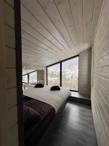 斯拉夫西克Mirest - котедж в горах із чаном-джакузі的一张大床,位于带大窗户的房间里