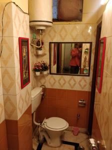 新德里Deer park Studio Flat (1 BHK)的一间带卫生间的浴室和一个拍照的人