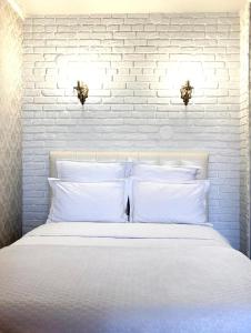 科克舍套1-комнатная квартира的白色卧室设有白色砖墙和一张床