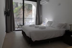 卡科佩特里亚Rifugio Retreat Bed&Breakfast的一间卧室配有一张带白色床单的床和一扇窗户。