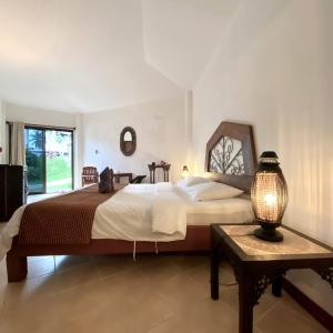 苏梅岛La Casa Bianca Samui的一间卧室配有一张大床和一张带台灯的桌子