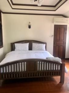 清迈SJ House的一间卧室配有一张大床和木制床头板
