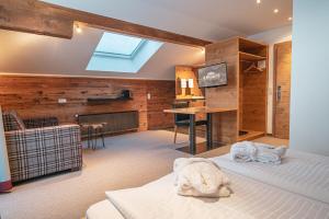 布兰德Alpen Suites Brandnertal的客房设有两张床、一张桌子和一台电视。