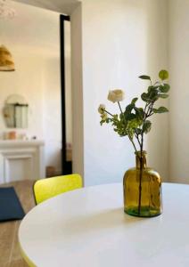 马赛Minimalistic style of Baille by Weekome的白色桌子上花的黄色花瓶