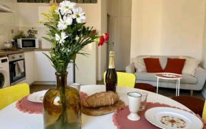 马赛Minimalistic style of Baille by Weekome的一张桌子,上面放着一瓶葡萄酒和一瓶鲜花