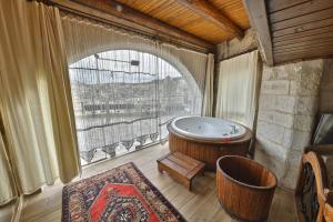 格雷梅迪万岩洞酒店的客房设有浴缸和大窗户。