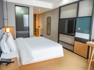 喀什尚客优品喀什古城万达酒店的卧室配有一张白色大床和电视。