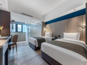 深圳兰欧酒店深圳东门罗湖口岸店的酒店客房配有两张床和一张书桌