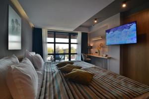 巴尔奇克Boutique Hotel by BlackSeaRama的一间卧室设有一张大床和一台平面电视。