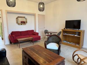 甘冈Auberge Ti'gousket的客厅配有红色沙发和电视