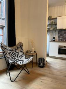 那慕尔Suite 26-Appartement au coeur de Namur的一间带椅子的客厅和一间厨房