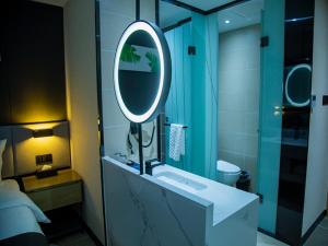 Pa-ch'u-hsien尚客优品酒店巴楚军民路巴尔楚克小镇店的浴室设有水槽和镜子,位于柜台上