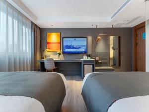 深圳兰欧酒店深圳东门罗湖口岸店的卧室配有一张桌子,墙上配有电视