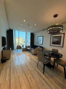 利雅德4Leisure Suites DAMAC Esclusiva Towers的客厅配有吊灯和桌椅