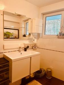 HesperangeHesp Guest House的白色的浴室设有水槽和窗户。