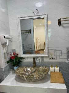 河内Nhà Nghỉ Huyền Anh的一间带石制水槽和镜子的浴室