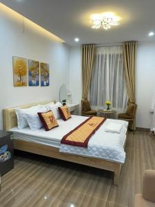 河内Nhà Nghỉ Huyền Anh的一间卧室配有一张大床和两把椅子