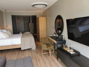 吉塞尼Ubucuti Lodge的酒店客房配有一张床和一张带镜子的书桌