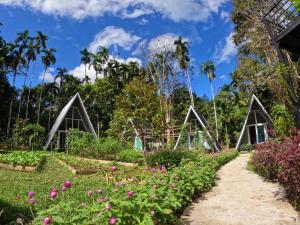 Ample Forest Khao Sok Farmstay的一座花粉的建筑前的花园