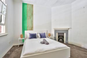悉尼Spacious 3 Bedroom House City Centre Millers Point 2 E-Bikes Included的卧室配有1张白色床和壁炉