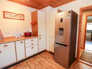 PaibleAr Dachaigh的厨房配有不锈钢冰箱和白色橱柜