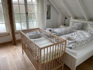 瓦伦多夫Fachwerkhaus am See mit privat Strand的一间卧室配有一张床和一张婴儿床