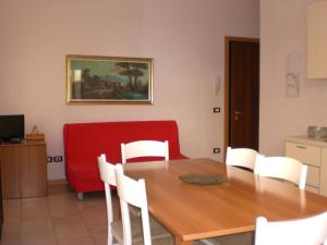 利多迪耶索罗Villa Nicole 2 camere的一间带桌子和红色沙发的用餐室