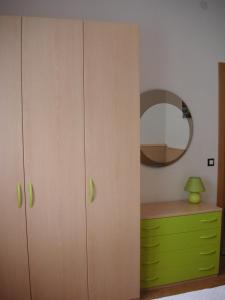 利多迪耶索罗Villa Nicole 2 camere的一间卧室配有绿色梳妆台和镜子