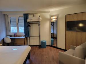 沙托鲁沙托鲁宜必思酒店的酒店客房配有一张床铺、一张桌子和一张书桌。
