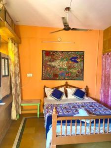 斋沙默尔Little Prince Home Stay的一间卧室配有一张橙色墙壁的床