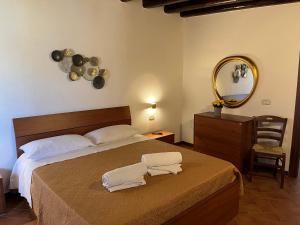 兰佩杜萨Residence Villa Felice的一间卧室配有一张带镜子和椅子的床