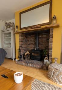 比德内尔Church Cottage的客厅设有砖砌壁炉和平面电视