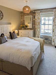 比德内尔Church Cottage的卧室设有一张白色大床和一扇窗户。