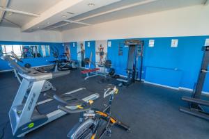 科拉雷侯Arena Beach的一间健身房,里面设有蓝色的墙壁和自行车