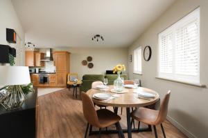 马姆斯伯里Stylish Flat With Sofa Bed in Malmesbury!的厨房以及带桌椅的起居室。