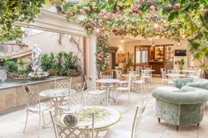 佛罗伦萨Adler Cavalieri Hotel-Private Spa & Gym的庭院设有桌椅和鲜花