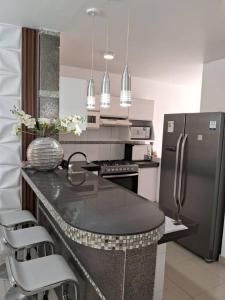 皮乌拉Dpto. contemporáneo y acogedor的厨房配有黑色柜台和冰箱。