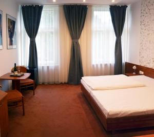 帕尔杜比采庄园牧场旅馆的卧室配有床、桌子和窗户。