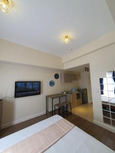 宿务Arlowes Cebu at 20f Grand Residences Cebu的卧室配有一张床,墙上配有电视。