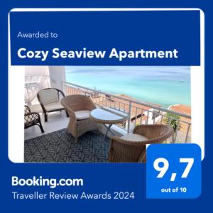 希维利Cozy Seaview Apartment的阳台的阴暗图片,配有椅子和桌子