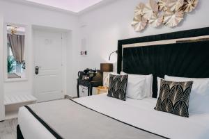 罗马Imperial Rhome Guest House的一间卧室配有一张白色大床和黑色床头板
