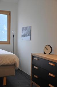VellaPanoramic Ecodesign Apartment Obersaxen - Val Lumnezia I Vella - Vignogn I near Laax Flims I 5 Swiss stars rating的一间卧室配有一张床和一个挂帽子的梳妆台