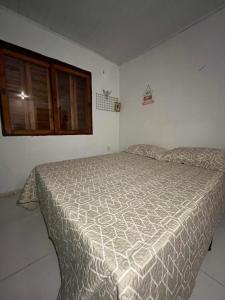 卡庞达卡诺阿Legítima casa de praia的一间卧室配有一张床和被子