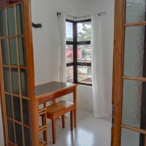 卢纳将军城1-BR flat with kitchen private bath hot and cold shower的客房设有木桌和窗户。